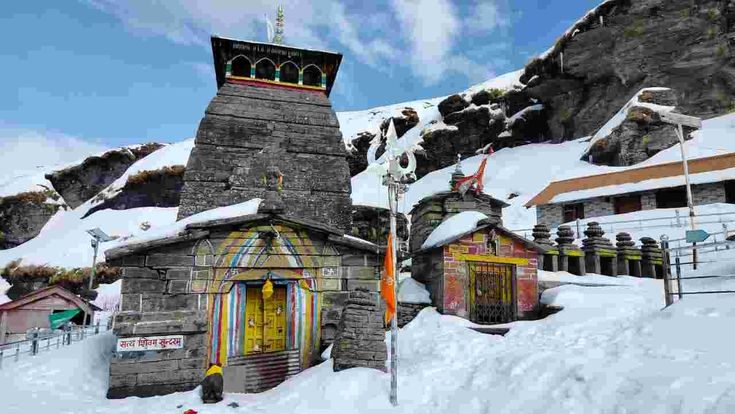 Chopta Tungnath in Spring Season with colorful entrance, surrounding shrines, and Himalayan mountain backdrop. Journeymitr